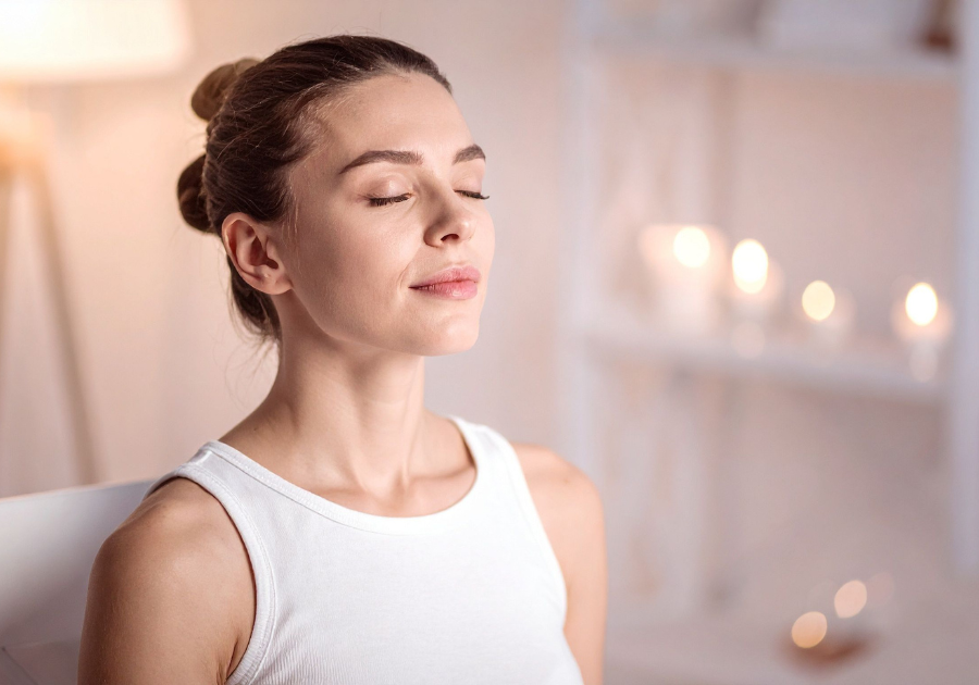 Woman practicing slow, mindful breathing with eyes closed in a calm, peaceful setting, supporting nervous system regulation and relaxation.